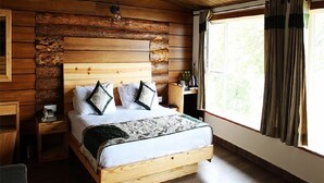 A wooden cabin-style bedroom with a bed, nightstands, and a window with curtains. - Jharipani Castle (Dehradun)