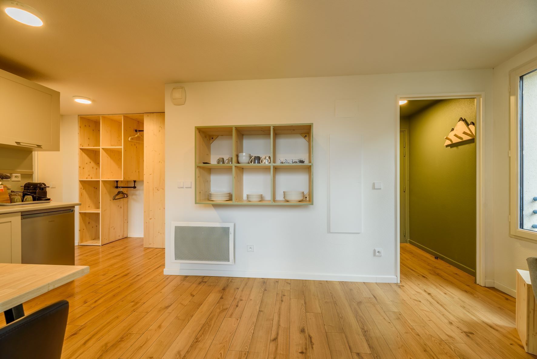 Una cocina moderna con armarios de madera, estufa integrada y comedor con mesa y sillas.