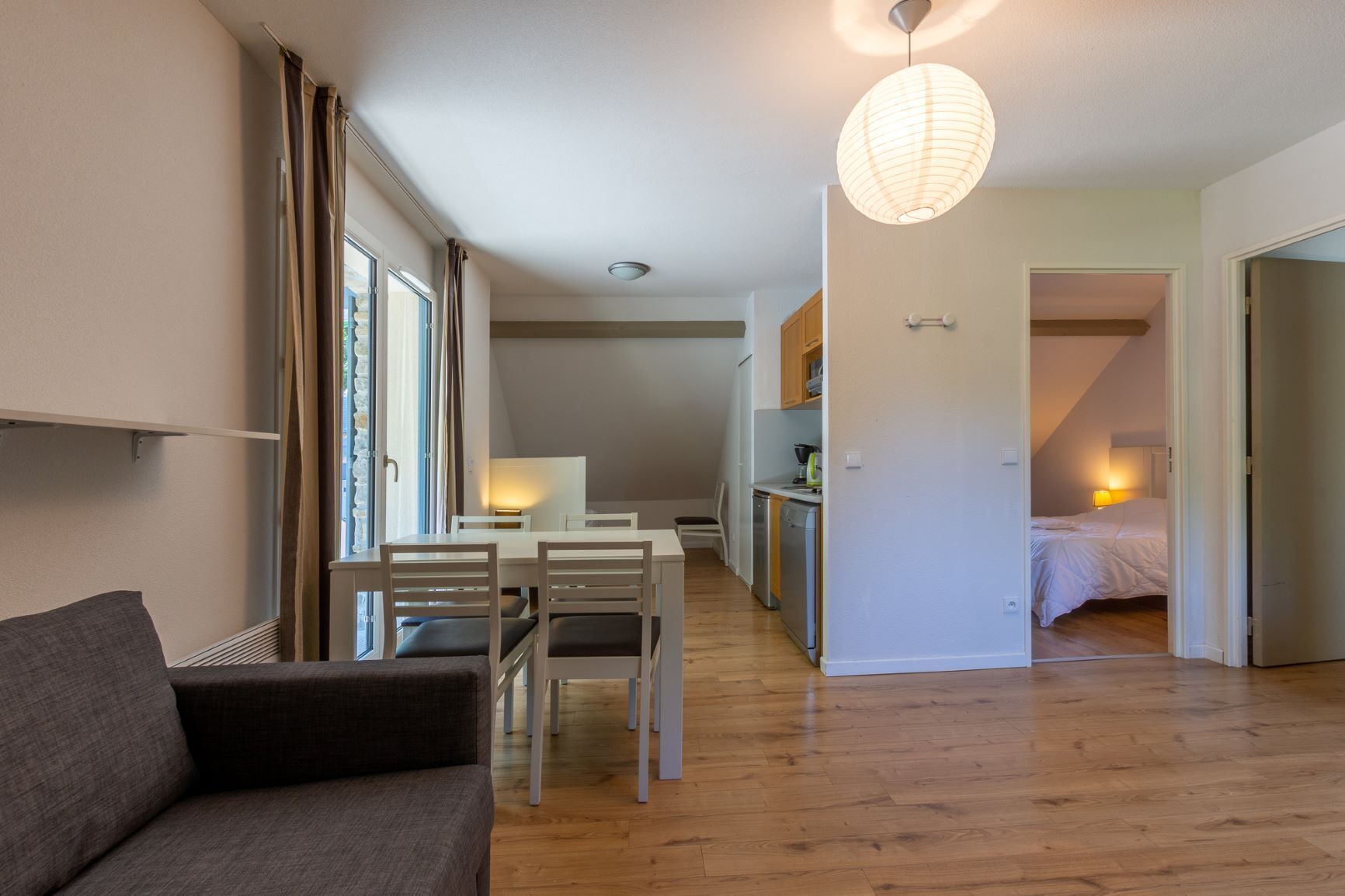 Un appartamento moderno con zona pranzo, cucina e camera da letto.