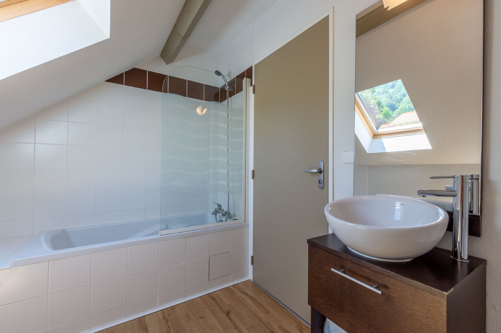 A modern bathroom with a glass-enclosed shower, a freestanding bathtub, and a large vessel sink.