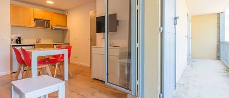 A modern apartment with a kitchen, dining area, and a balcony.