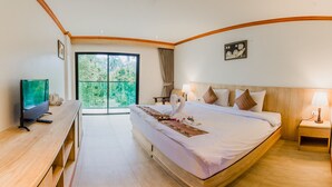 Habitación de hotel con una cama grande, televisión, escritorio y vistas al exterior.