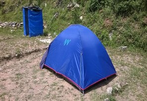 A blue tent set up on a grassy area with a rocky path nearby. - Janardan Resort Churaini - Campsite (Kosiyakutoli)