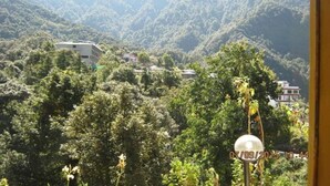 Un paisaje montañoso con abundante vegetación y algunos edificios.