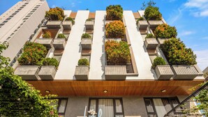 A modern building with a flat facade, multiple balconies with plants, and a sign reading "Lahone". - Lahome Boutique Villa and Apartment (Da Nang)