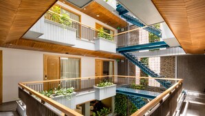 A multi-level atrium with wooden railings, a central staircase, and potted plants. - Lahome Boutique Villa and Apartment (Da Nang)