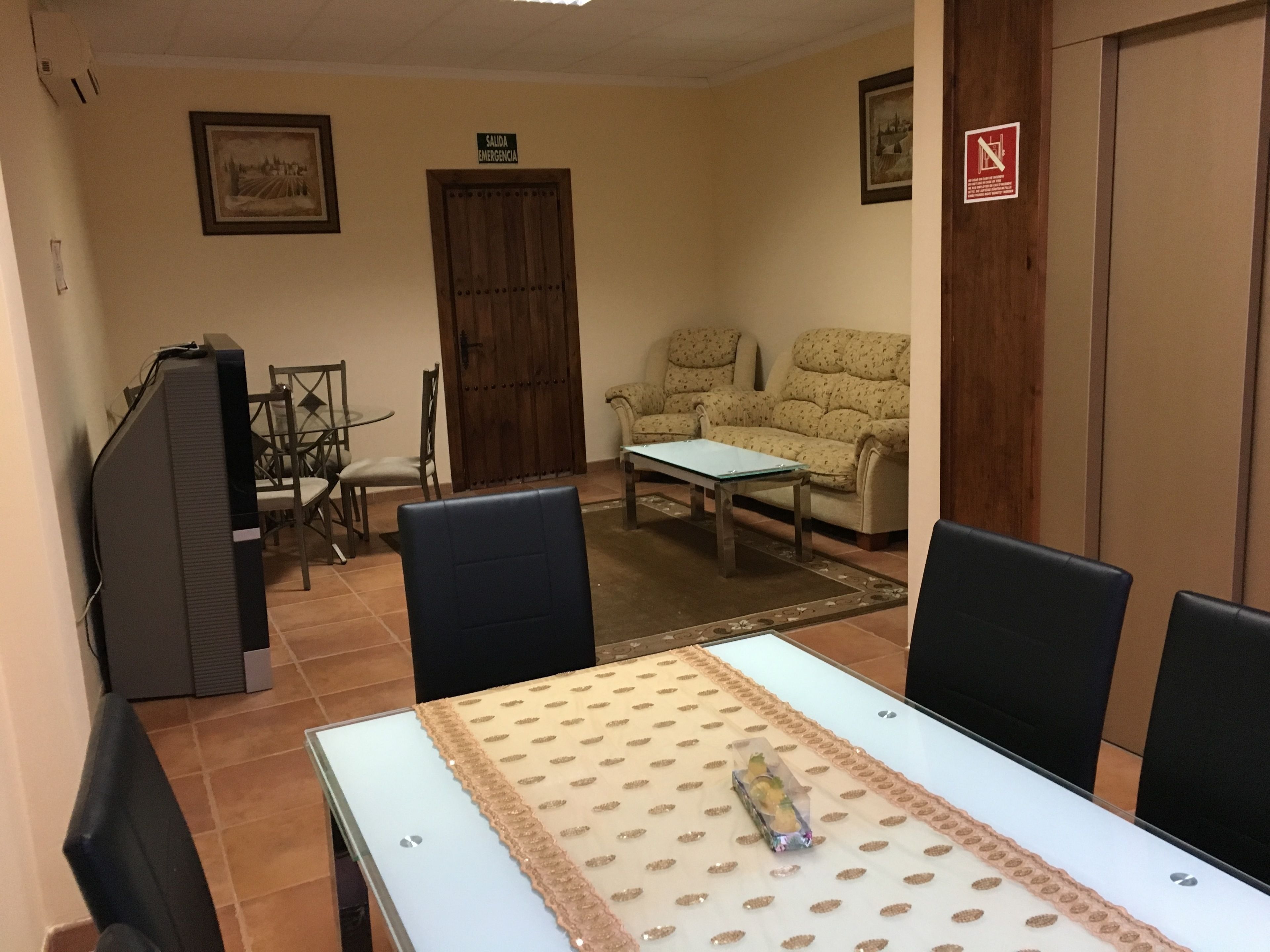 Un comedor con una mesa, sillas, un sofá y una televisión.