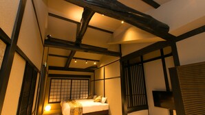 Ein traditionelles japanisches Schlafzimmer mit Tatami-Boden, einem niedrigen Bett und einer Schiebetür.