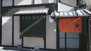 Ein traditionelles japanisches Gebäude mit einem Ziegeldach, einer Schiebetür und einem Schild mit japanischen Schriftzeichen.