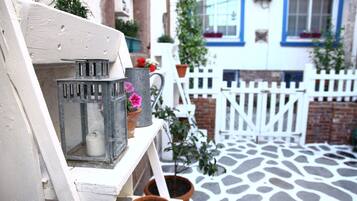 A white wooden bench with a metal lantern and a potted plant.