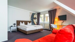 A bedroom with a bed, a desk with a chair, a TV, and a window with curtains. - Landhotel Schloss S örgenloch (Sörgenloch)