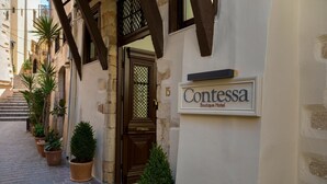 A narrow alley with a boutique hotel entrance, potted plants, and a sign for 'Contessa Boutique Hotel'. - Contessa Boutique Hotel (Chania)