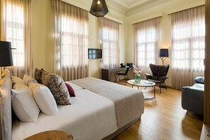 A hotel room with a large bed, a desk, a chair, and a TV. - Contessa Boutique Hotel (Chania)