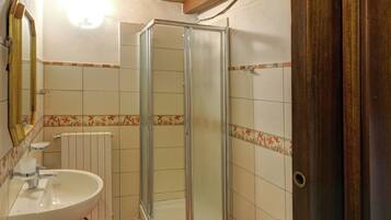 A bathroom with a shower, toilet, and sink.
