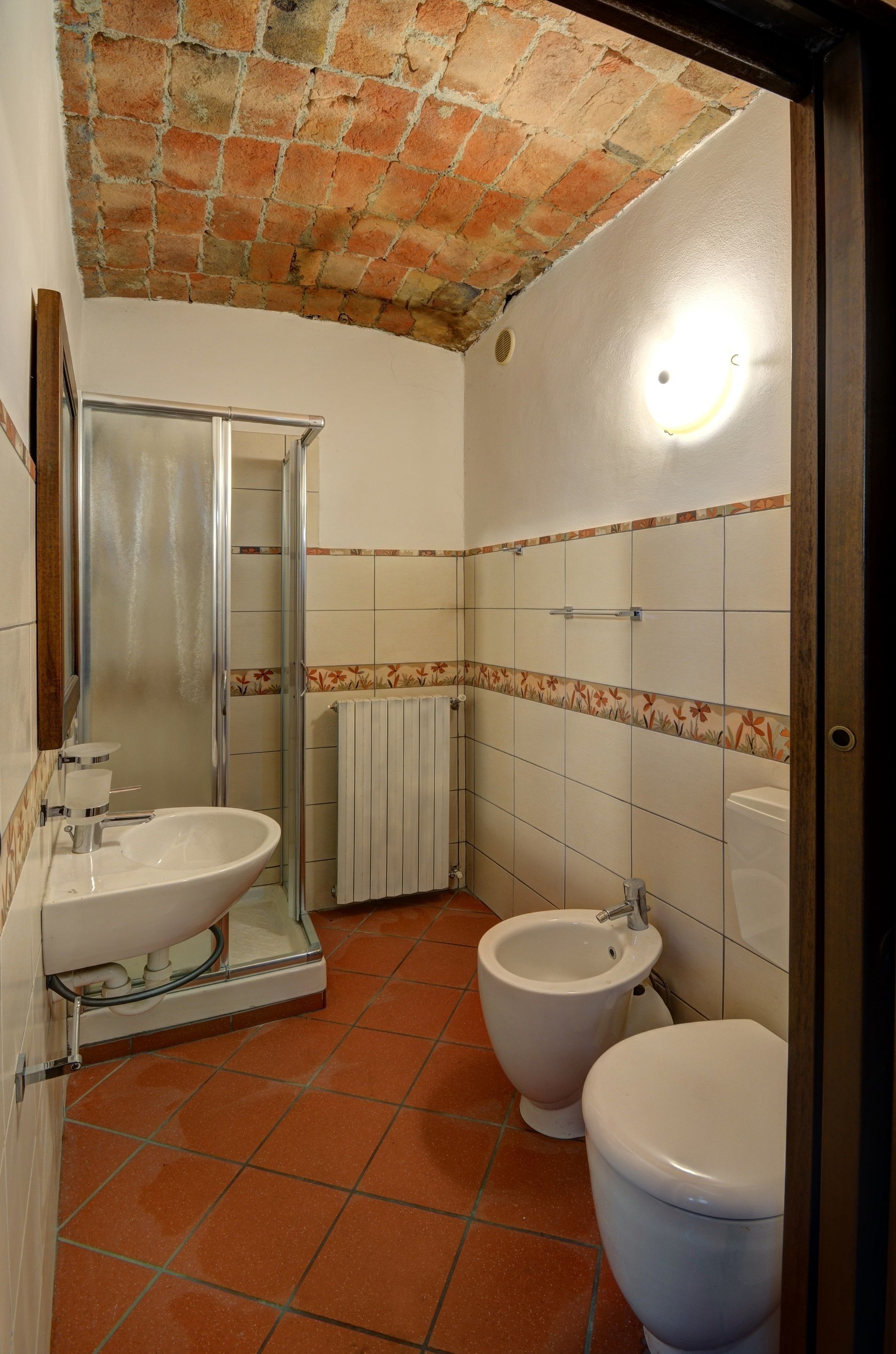 Ein Badezimmer mit Dusche, Waschbecken, Bidet und Toilette.