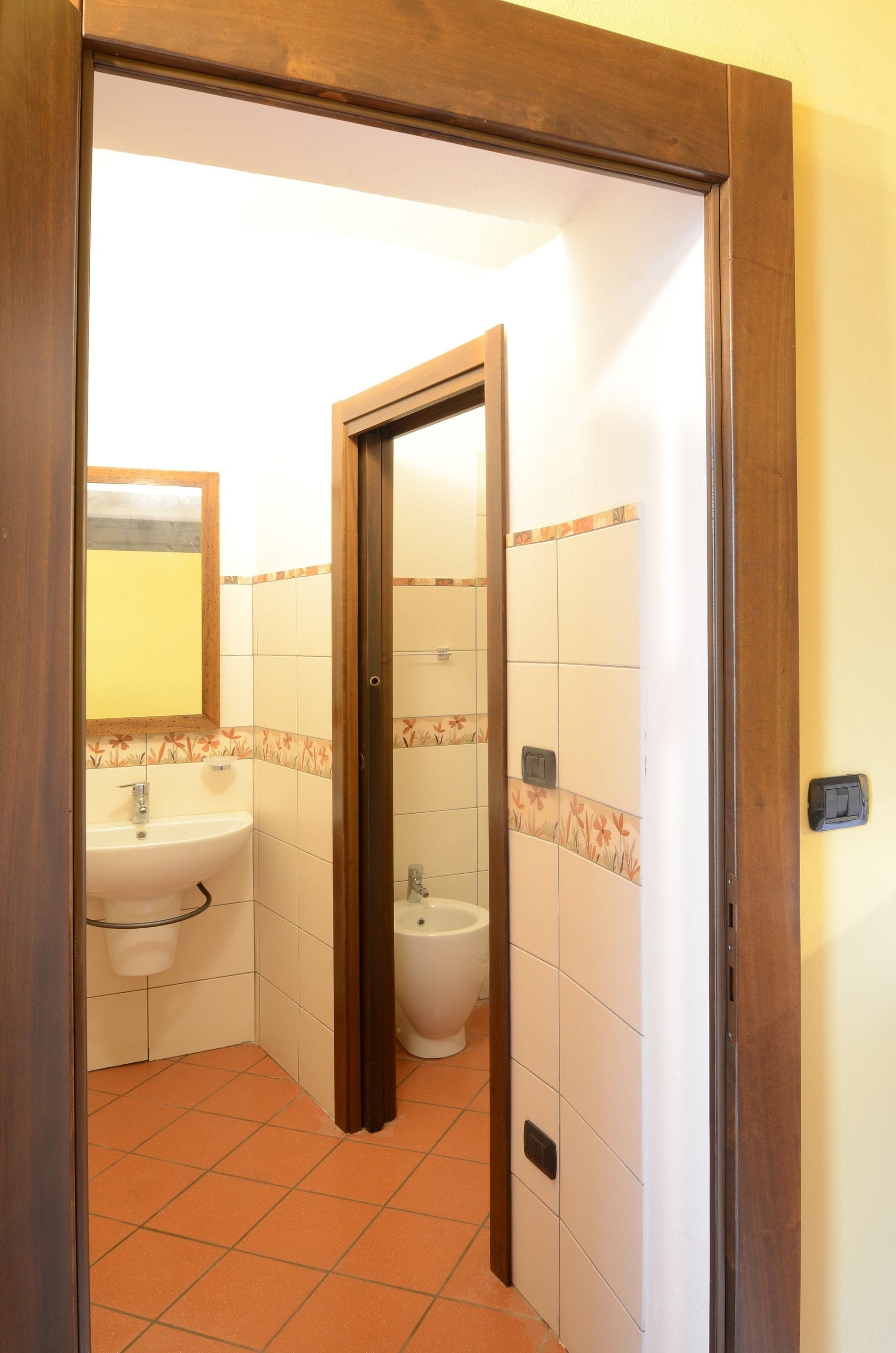 A bathroom with a sink, toilet, and mirror.
