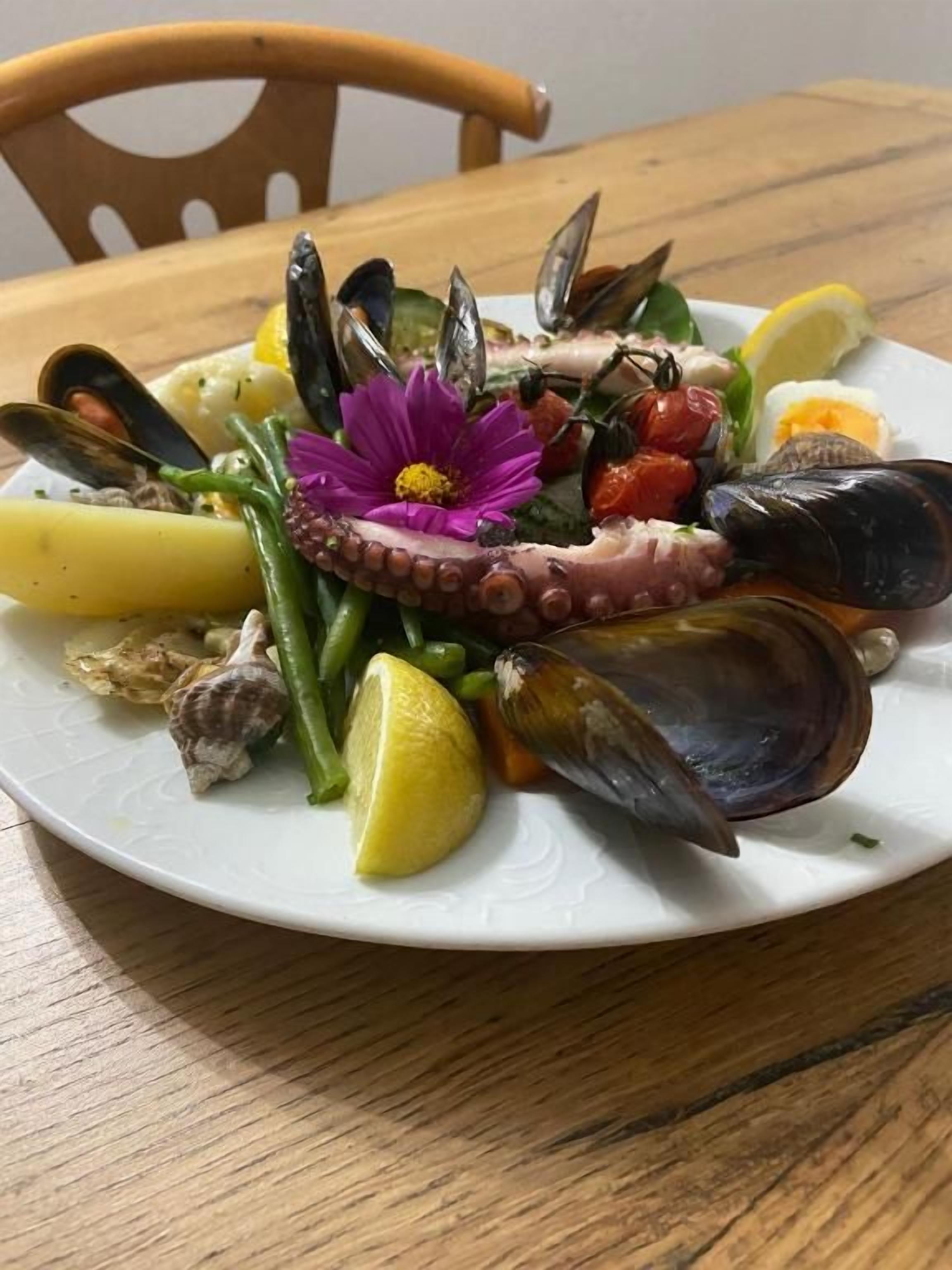 Prato de frutos do mar com mexilhões, polvo e legumes.
