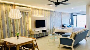 Une chambre d’hôtel moderne dotée d’un coin repas, d’une télévision, d’un lit et d’un balcon.