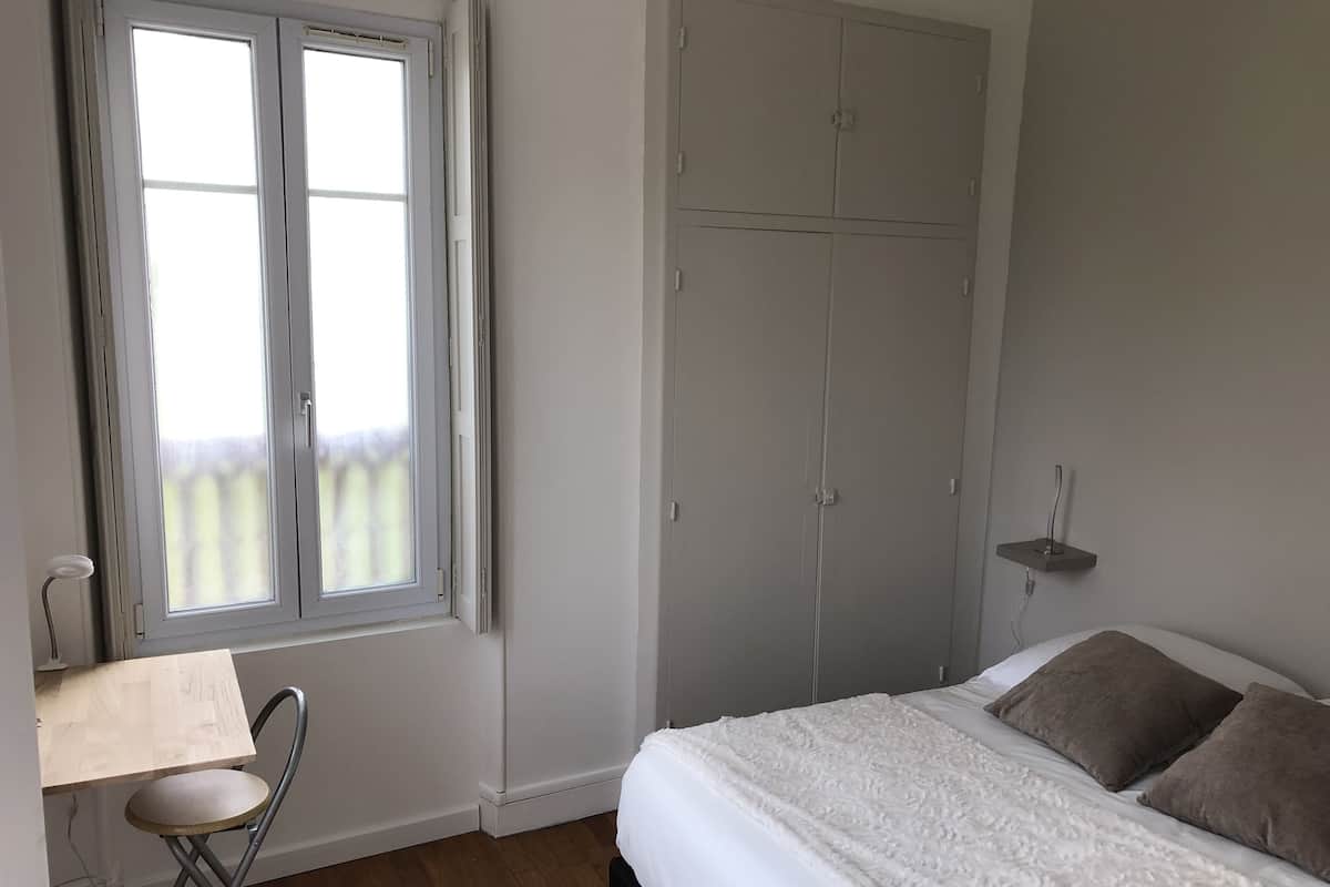 Une chambre à coucher comprenant un lit, un bureau avec une chaise et une armoire.