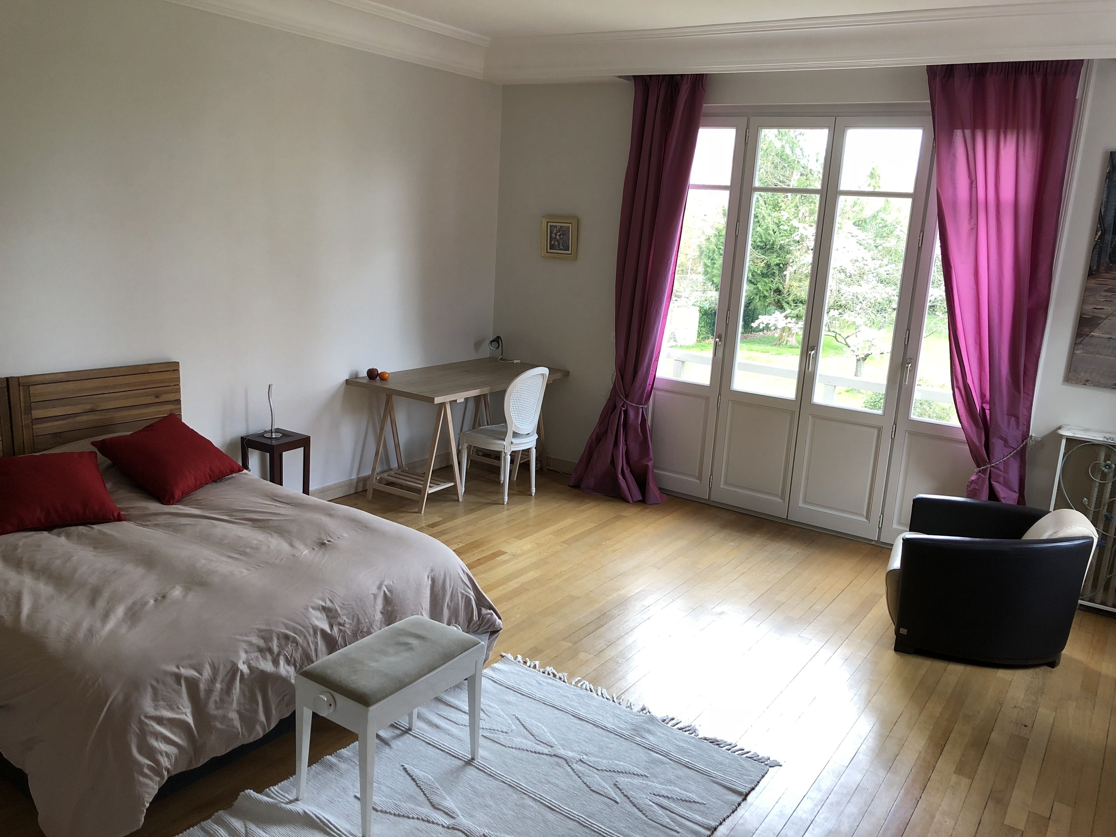 A bedroom with a bed, a desk, and a chair.