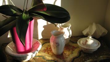 Una mesa con una planta en maceta, una jarrón, una tetera y una taza de té.