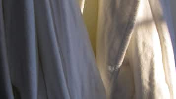 Primer plano de un tejido blanco, posiblemente una cortina o un paño, con una textura suave y pliegues.