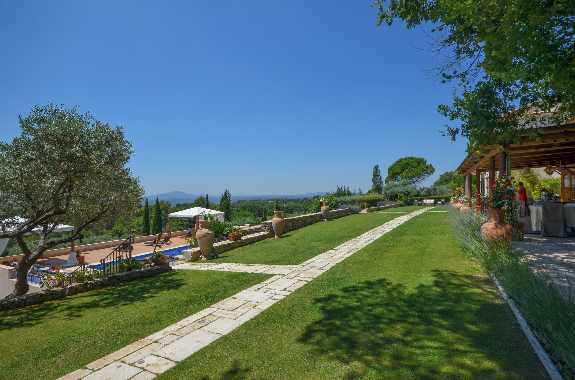 A well-maintained garden with a stone pathway, outdoor seating, and a view of the landscape.