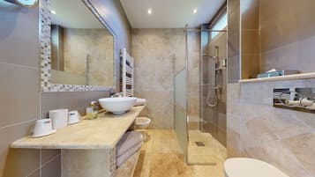 A modern bathroom with a large sink, mirror, and glass-enclosed shower.