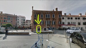 A street view with a building featuring arched windows and a red awning. - Ca Sarasina (Venice)