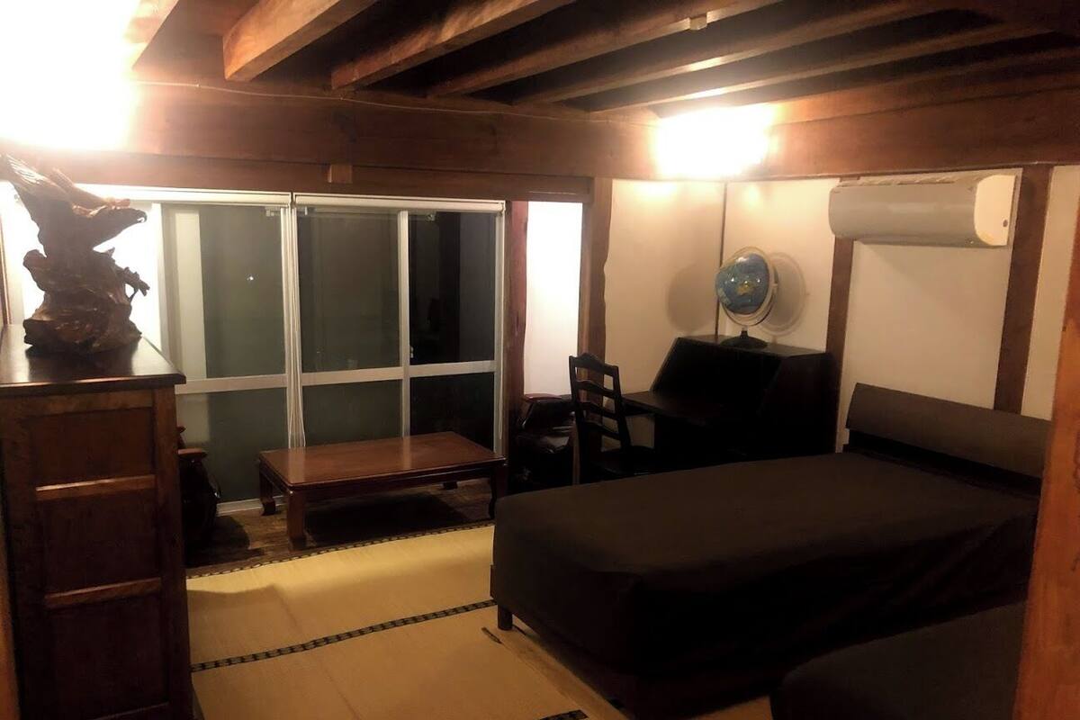 A room with a bed, a desk, a chair, and a window.
