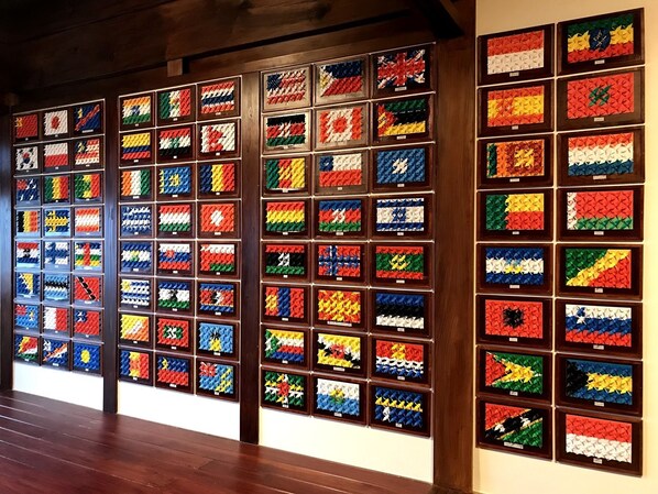 A wall displaying a collection of colorful, patterned flags in framed sections.