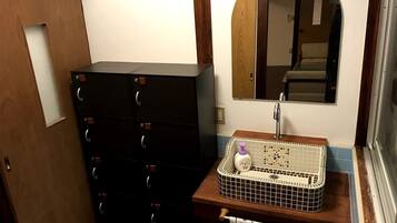 A bathroom with a wooden cabinet, a tiled sink, and a mirror.