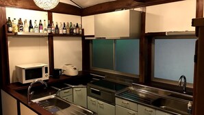 Cocina compacta con microondas, tostadora y pileta. Hay placares y una ventana sobre la pileta.