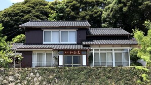 Un edificio japonés tradicional con tejado de tejas y un letrero en japonés.