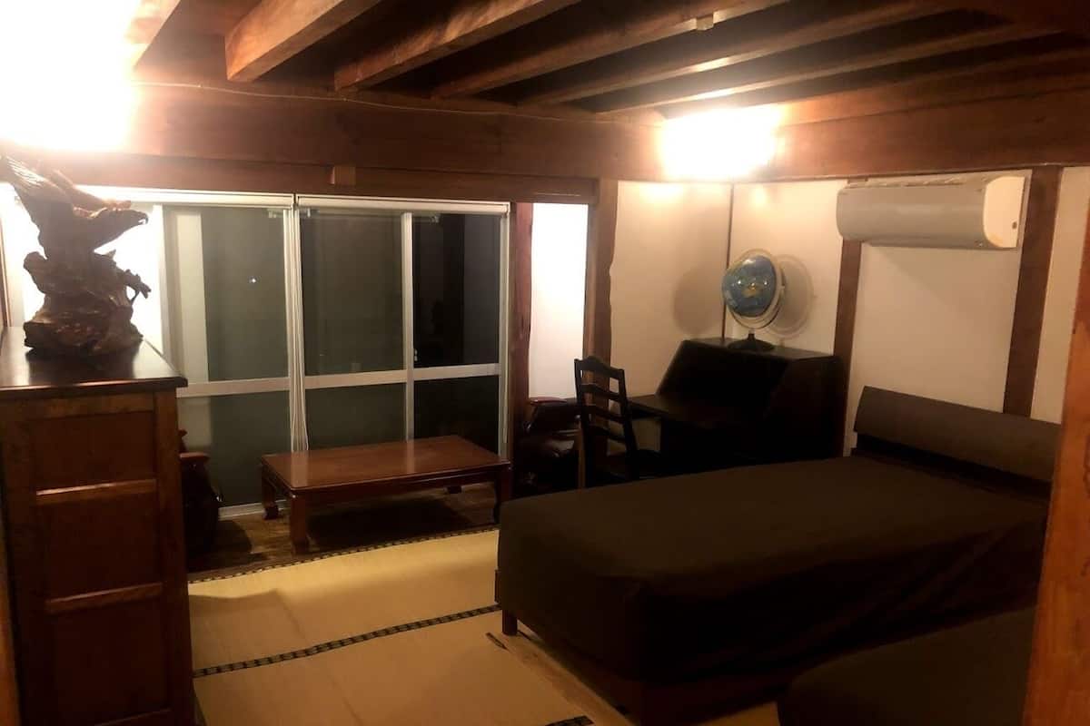 A room with a bed, a desk, a chair, and a window.