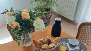 A breakfast table with a variety of food items, including bread, fruit, and beverages. - Cante Grillet (Lacoste (Provence))