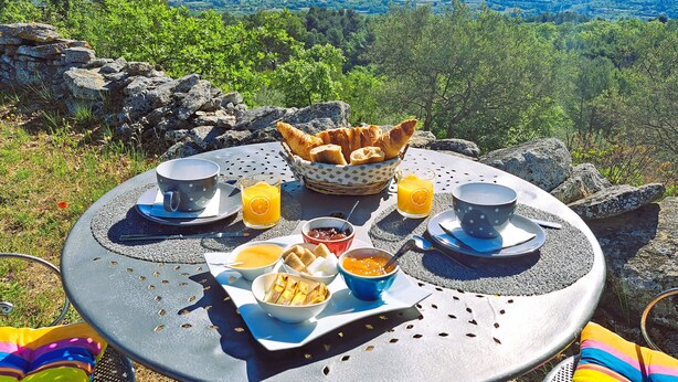 A table set with breakfast items and a scenic view. - Cante Grillet (Lacoste (Provence))