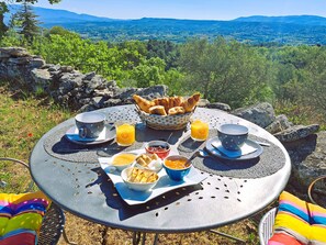 Mesa posta com itens de café da manhã e vista panorâmica.