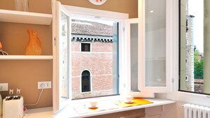A modern kitchen with a window view of a historic building, a toaster, and a coffee machine. - Vivaldi room - Biennale by Wonderful Italy (Venice)