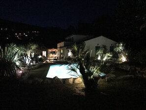 Een buitenzwembad, parasols bij het zwembad en ligstoelen