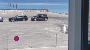 A parking lot with cars and a view of the sea through a window. - Samsø Perlen (Samsø)