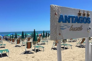A beach with a sign reading "ANTAGOS beach" and rows of beach chairs and umbrellas. - Hotel Antagos (Montesilvano)