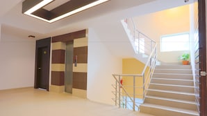 A modern interior with a staircase, elevator, and a potted plant. - Holy Inn (Sylhet)