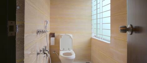 Un baño con inodoro, ducha y ventana.