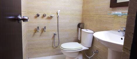 A small bathroom with a toilet, sink, and shower.