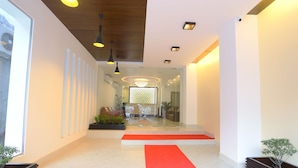 A modern hotel lobby with a red carpet, glass walls, and a wooden ceiling. - Holy Inn (Sylhet)