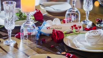 A table set for a meal with candles, a bottle of champagne, and a menu card.