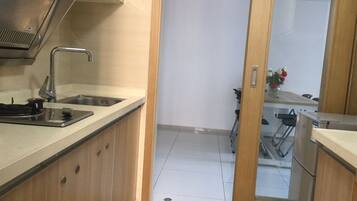 Une cuisine équipée d’un évier en acier inoxydable, d’une cuisinière et de meubles de rangement en bois.