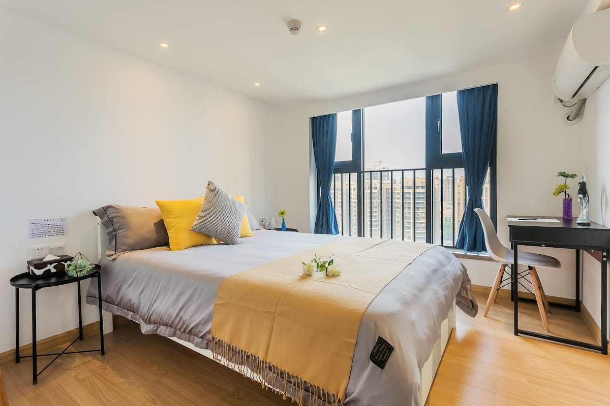 Une chambre d’hôtel moderne avec un grand lit, un bureau et une vue sur la ville.