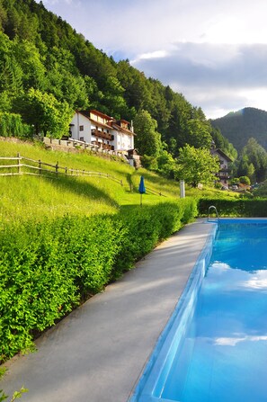 Piscine extérieure en saison, parasols, chaises longues